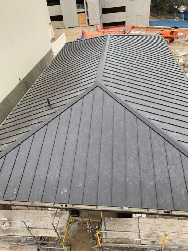 Commercial metal roof construction with crane equipment in Montclair